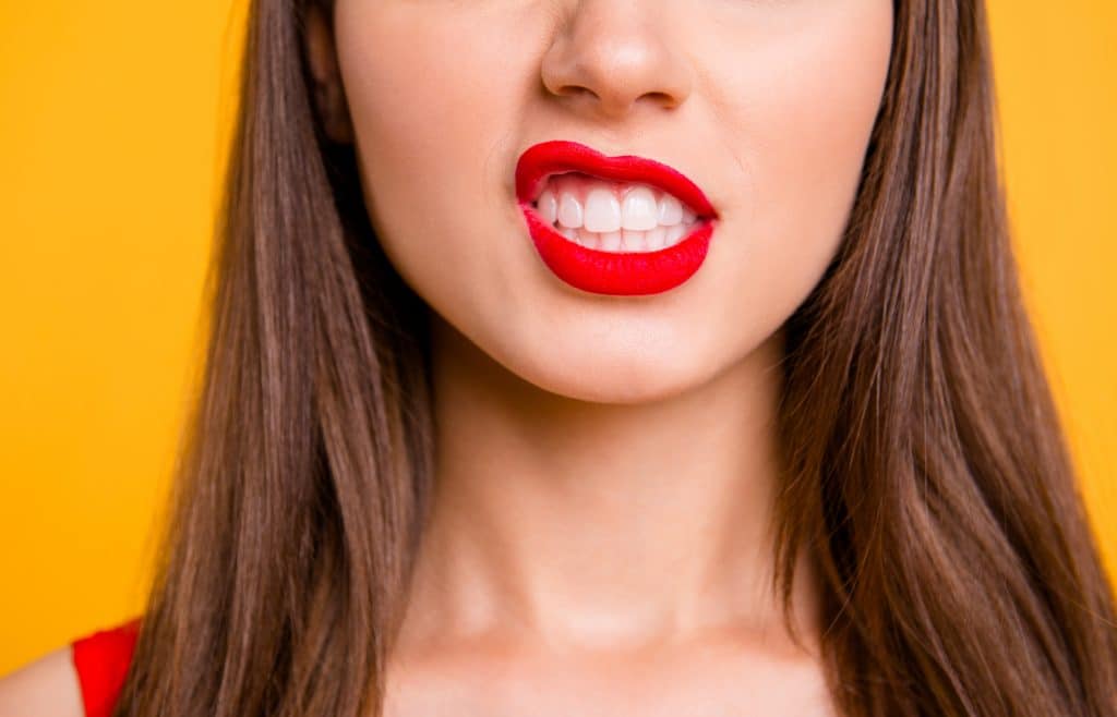 Close up cropped photo of big full natural lips brunette hair isolated on vivid yellow background