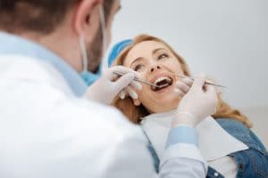 I better check it, than treat it. Wise attractive young woman being serious about her health and paying a regular visit to her dentist while sitting in a special chair