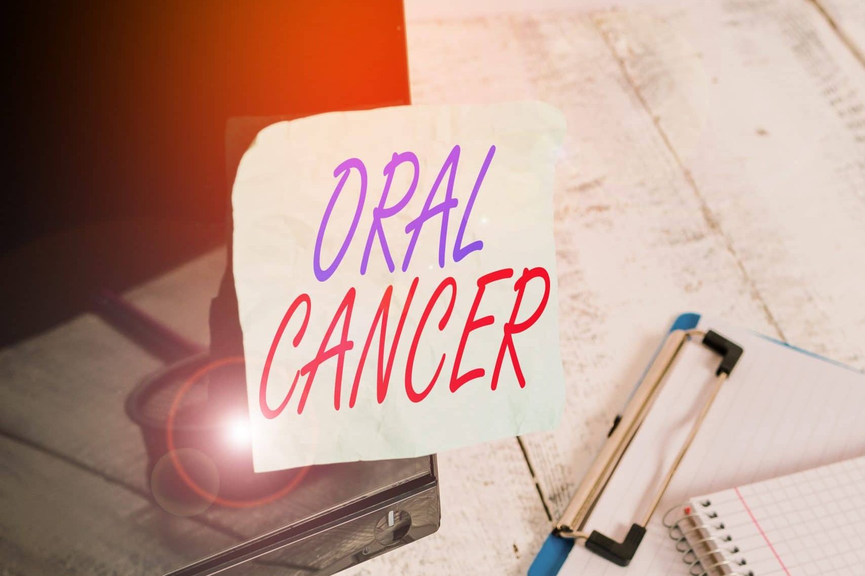 Conceptual hand writing showing Oral Cancer. Concept meaning the cancer of the lining of the lips mouth or upper throat Note paper taped to black screen near keyboard stationary