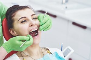 Dentist curing a female patient in the stomatology. Early prevention and oral hygiene concept.