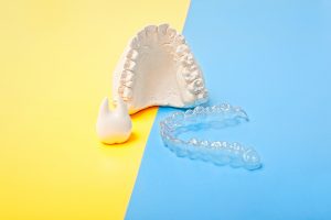 Orthodontic dental theme on blue and yellow background.Transparent invisible dental aligners or braces aplicable for an orthodontic dental treatment