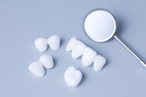 Dental mirror and dentures on a light blue background