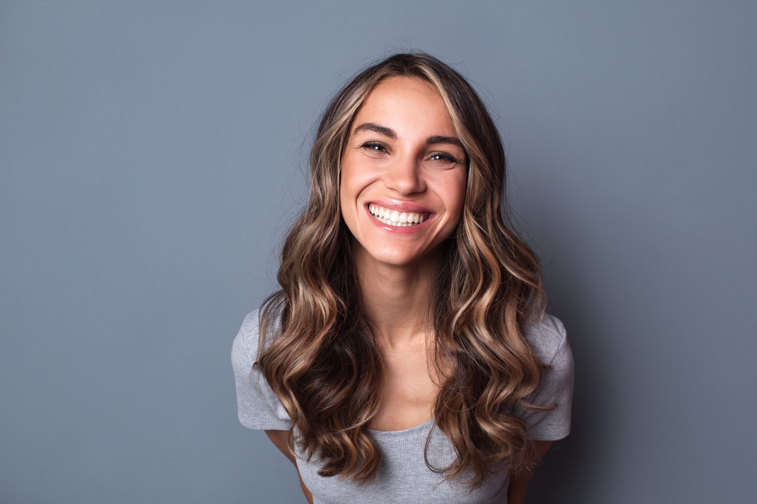 Portrait of young beautiful cute cheerful girl smiling looking at camera. Isolated close-up portrait of woman.