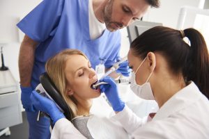 Young woman is getting treatment in dentist's office