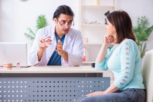 The middle-aged woman visiting male doctor stomatologist