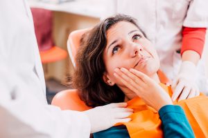 Patient with painful toothache  siting in chair at dental office