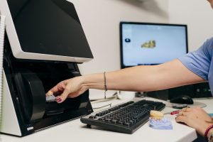 Cropped caucasian woman working with computer at dental laboratory