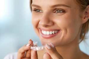 White Smile. Portrait Of Beautiful Smiling Woman With Healthy Straight White Teeth Holding Teeth Whitening Tray, Girl Using Dental Whitener. Dental Beauty Treatment Concept. High Resolution Image