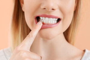 Beautiful woman with healthy teeth on color background, closeup