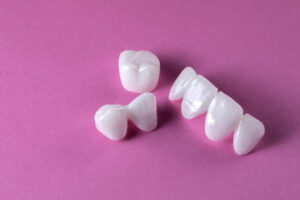Zircon dentures on a pink background - Ceramic veneers - luminee