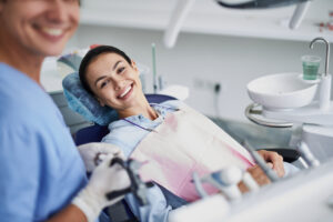 I care about my teeth. Portrait of charming girl sitting in dentist chair while looking at camera and smiling