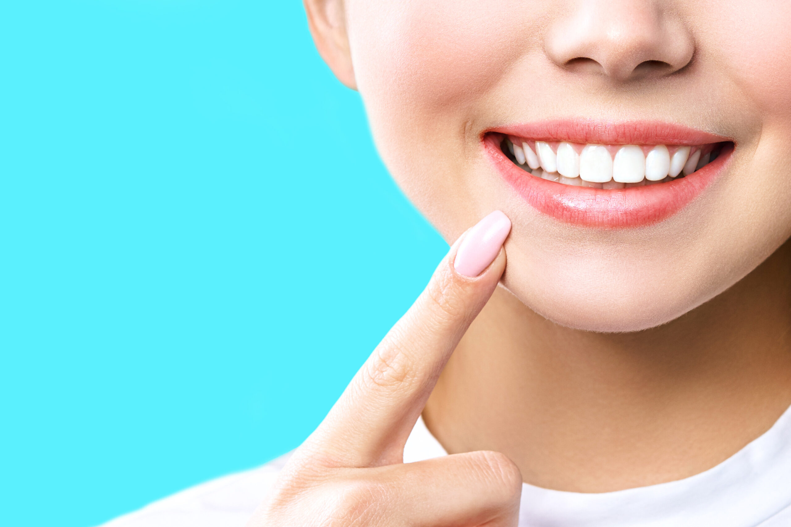 Perfect healthy teeth smile of a young woman. Teeth whitening. Dental clinic patient. Image symbolizes oral care dentistry, stomatology. blue Background.