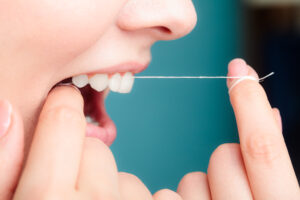 Oral hygiene and health care. Smiling women use dental floss white healthy teeth.